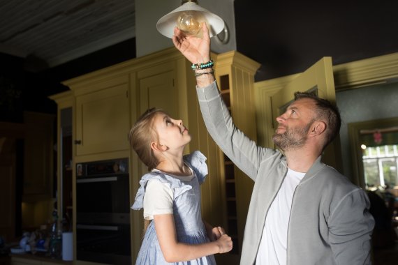 Father and daughter fixing a light bulb